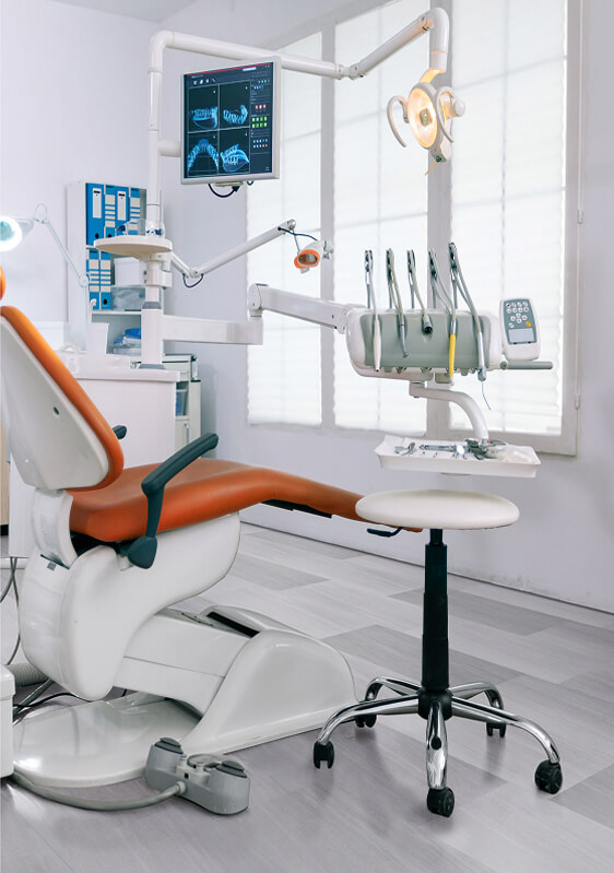 A modern dental office with an orange and white dental chair, overhead examination light, dental tools, and an X-ray monitor displaying dental images. The bright room features large windows and stylish TORLYS flooring throughout.